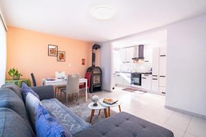 a living room with a blue couch and a kitchen at Scenic Alps View Getaway in Aquila