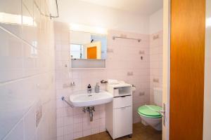 a white bathroom with a sink and a toilet at Scenic Alps View Getaway in Aquila