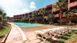 a hotel with a swimming pool and lounge chairs at Oliva Hotel Condominium Marrakech in Marrakesh
