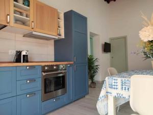 a blue kitchen with a stove and a table at Casa Peppo in Marciana +10 photos