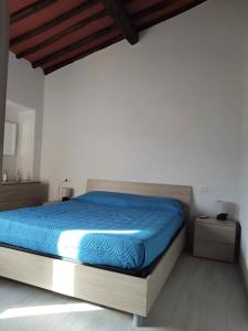 a bedroom with a bed with a blue blanket at Casa Peppo in Marciana