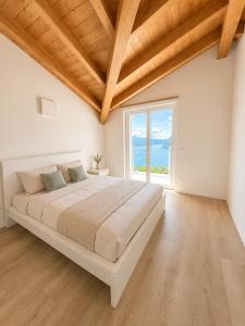 a bedroom with a large bed and a large window at Iseo Collection in Riva di Solto