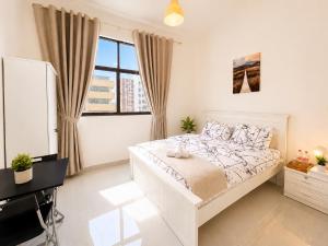 a white bedroom with a bed and a piano at Flora Residence in Abu Dhabi +27 photos