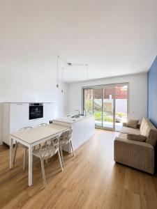 a kitchen and living room with a table and a couch at Iseo Collection in Riva di Solto