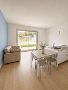 a white living room with a table and a couch at Iseo Collection in Riva di Solto +14 photos