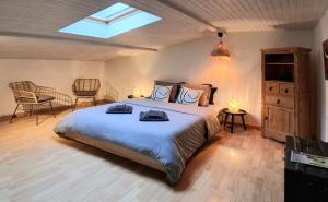 a bedroom with a large bed and a skylight at La petite Sorbonne - Chambres d'hôtes in Malleval