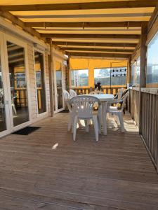 a patio with a table and chairs on a deck at Camping les charmettes- in Les Mathes