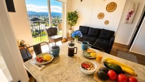 a table with fruits and vegetables on it in a living room at Acogedor departamento céntrico vista al lago in Villarrica