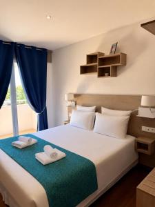 a bedroom with a large bed with two towels on it at Les Palmiers in Fréjus +152 photos