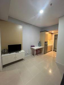 a living room with a flat screen tv and a table at Studio Apartemen Parahyangan Residence by Anton in Bandung