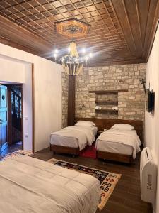 a bedroom with two beds and a chandelier at Oda e Gurit - Boutique Hotel in Berat
