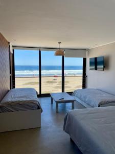 a bedroom with two beds and a view of the beach at Rompe Olas in Maitencillo
