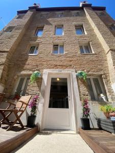 a brick building with a white door and flowers at casa dei pescatori sottomarina in Chioggia