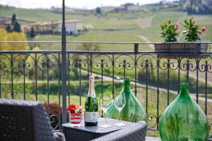 three bottles of wine sitting on a table on a balcony at Agriturismo Cascina Sciulun in Monforte dʼAlba