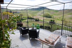 a balcony with a table and chairs and a view at Agriturismo Cascina Sciulun in Monforte dʼAlba