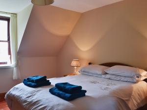 two blue towels sitting on top of a bed at Port-An-Eillean in Feorlean
