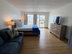a bedroom with a bed and a couch and a television at Beachcomber Motel in Ocean City