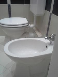 a bathroom with a white toilet and a sink at Klauzál Apartment in Szeged