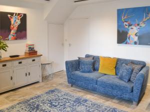 a living room with a blue couch and deer paintings at The Alnwick Townhouse in Alnwick