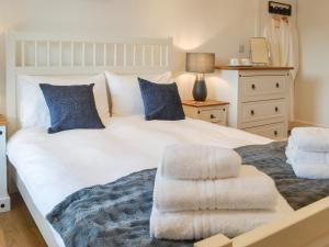 a bedroom with a large white bed with blue pillows at The Alnwick Townhouse in Alnwick +11 photos