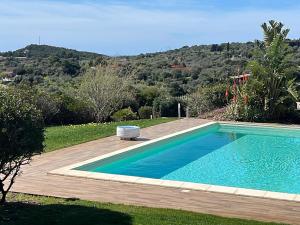 a swimming pool in a yard with a wooden deck at Villa Dama luxury in Alghero