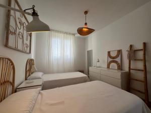 a bedroom with two beds and a dresser at Villa Chloe in Punta Grossa