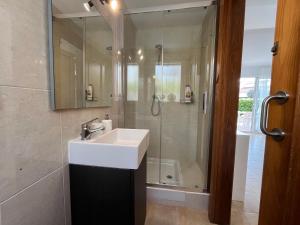 a bathroom with a white sink and a shower at Villa Chloe in Punta Grossa