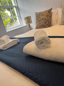 a couple of beds with towels on top of them at Wheatsheaf Inn in Brigsteer
