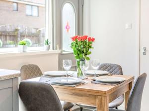 a wooden table with chairs and a vase of flowers on it at Hotspur View in Alnwick