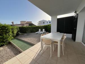 a white table and chairs on a patio at Villa Chloe in Punta Grossa