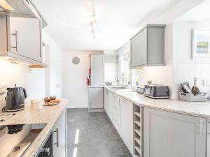 a kitchen with white cabinets and marble counter tops at Hotspur View in Alnwick +19 photos