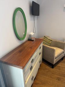 a mirror on top of a dresser with a chair at Wheatsheaf Inn in Brigsteer