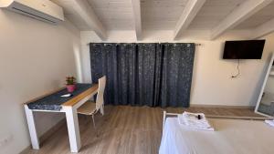 ein Zimmer mit Schreibtisch und Fernseher in einem Zimmer in der Unterkunft White Room "Dimore Lucane" in Ruoti