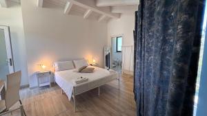 ein Schlafzimmer mit einem weißen Bett und einem blauen Vorhang in der Unterkunft White Room "Dimore Lucane" in Ruoti
