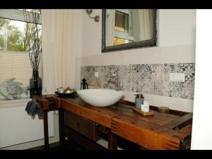 a bathroom with a white sink on a wooden table at Neu! Fewo Fiedler I in Finsterwalde +10 photos
