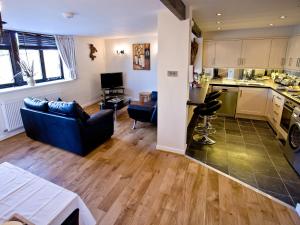 a living room with a couch and a kitchen at 3 Torwood Gables in Torquay