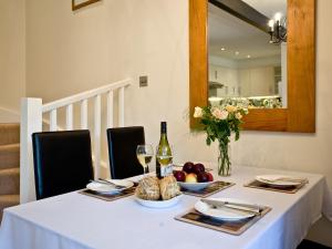 a table with a white table cloth and a bottle of wine at 3 Torwood Gables in Torquay +6 photos
