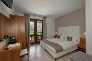 a hotel room with a bed and a desk and a desk at Hotel Residence La Pertica in Tremosine Sul Garda