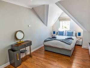 a bedroom with a bed with blue pillows and a mirror at Tay Views Apartment in Perth