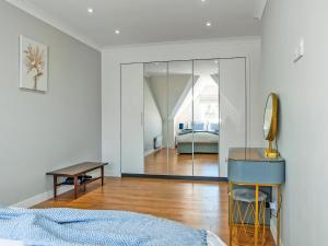 a bedroom with a bed and a desk and a mirror at Tay Views Apartment in Perth