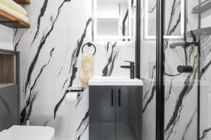 a bathroom with a black and white marble wall at Modern Cambridge North Flat in Milton