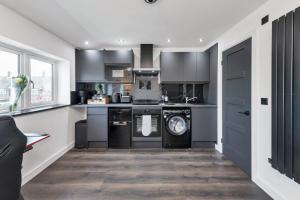 a kitchen with a washer and dryer in it at Modern Cambridge North Flat in Milton +16 photos