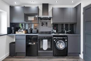 a kitchen with a washing machine and a washer at Modern Cambridge North Flat in Milton