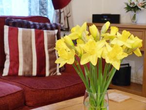 a vase filled with yellow flowers on a table at Watchkeeper's Cottage in Mundesley