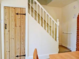 a staircase with a wooden door in a house at Watchkeeper's Cottage in Mundesley +26 photos