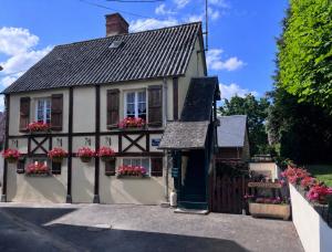 a house with flower boxes on the windows at The Bell`s End Cottage in Notre-Dame-du-Touchet