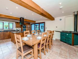 a kitchen with a wooden table and chairs at Rhiew Banc in Aberhafesp