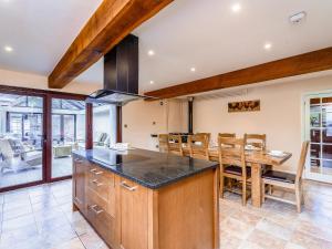 a kitchen with a table and a dining room at Rhiew Banc in Aberhafesp +21 photos