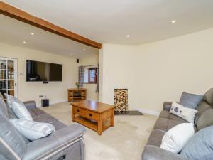 a living room with a couch and a coffee table at Rhiew Banc in Aberhafesp