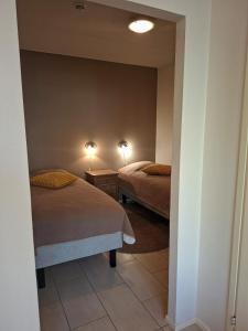 a bedroom with two beds and a mirror at Yllästar 3 - Cozy Stay in Magical Lapland in Äkäslompolo
